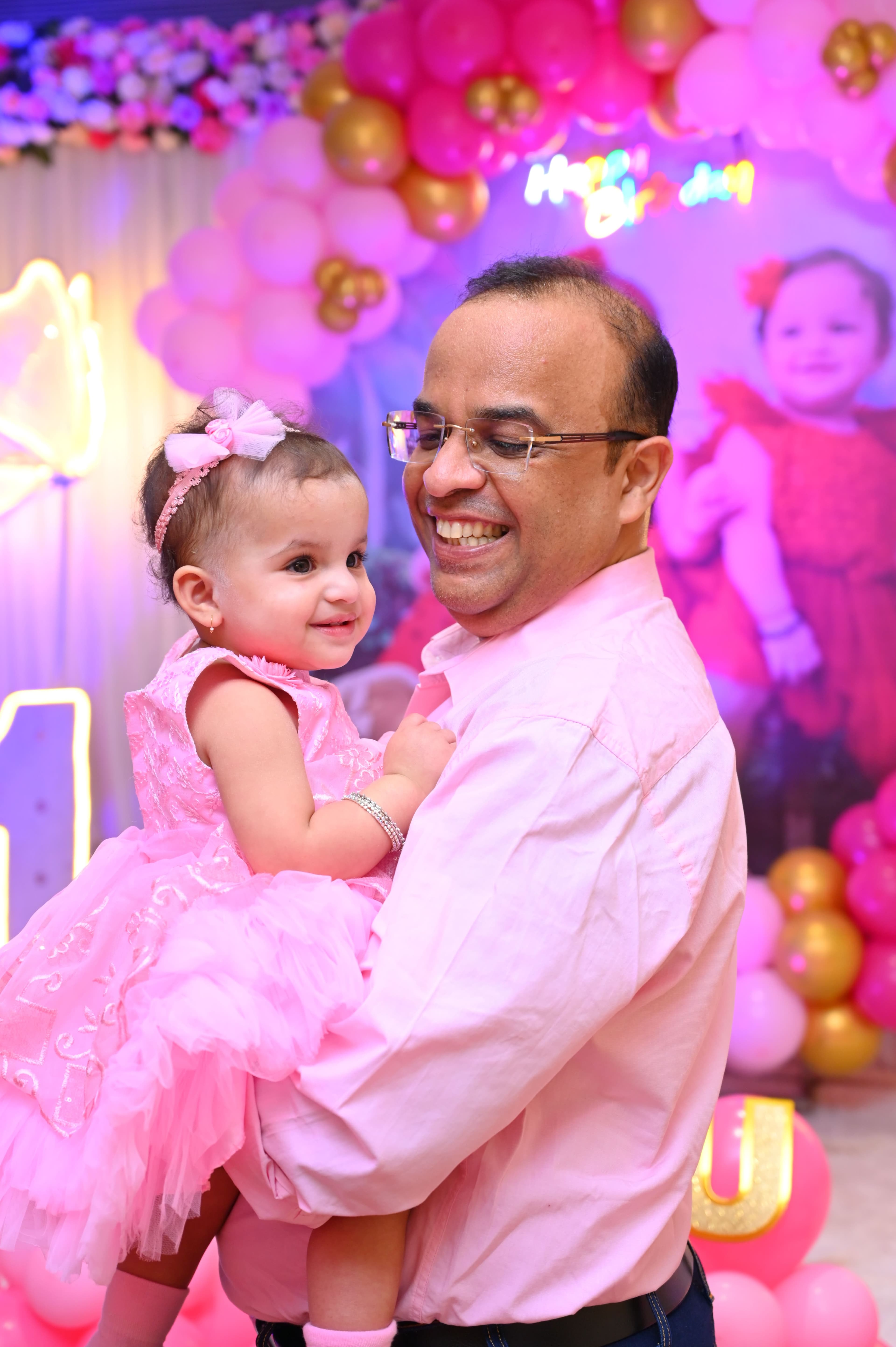 Father laughing with his baby daughter at her first birthday