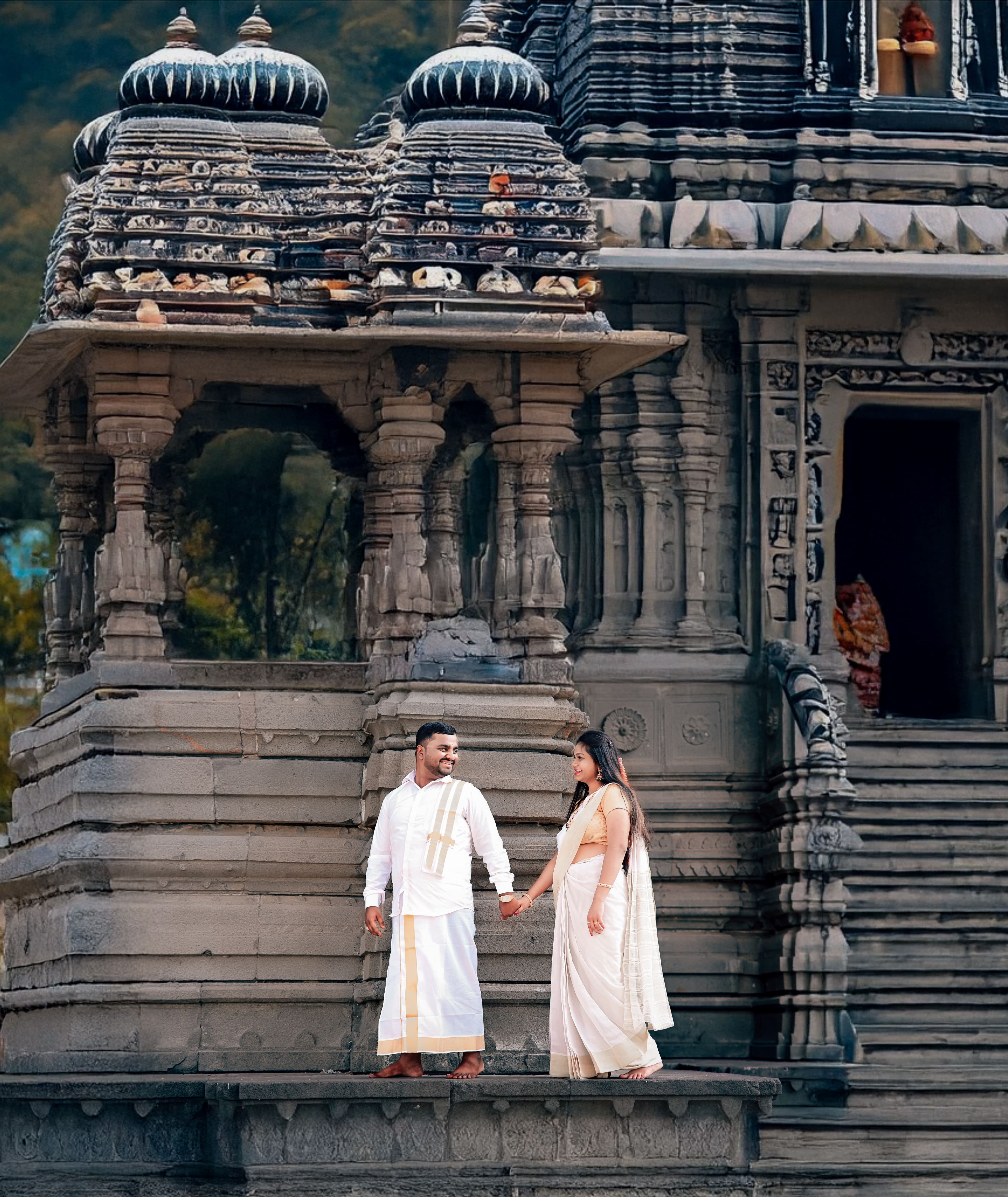 Couple in white traditional outfits before an ancient carved stone temple