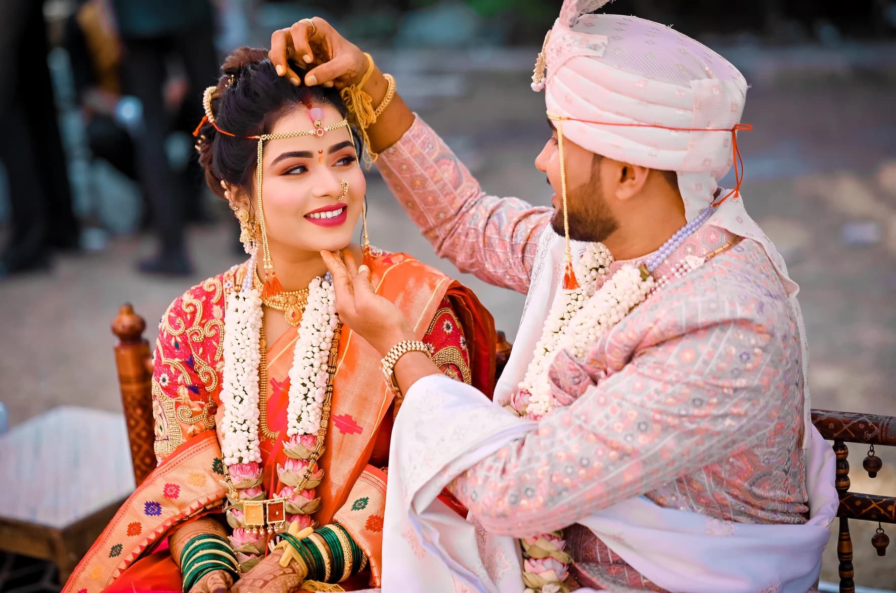 Groom adjusting the bride's mundavalya during a Maharashtrian wedding ritual