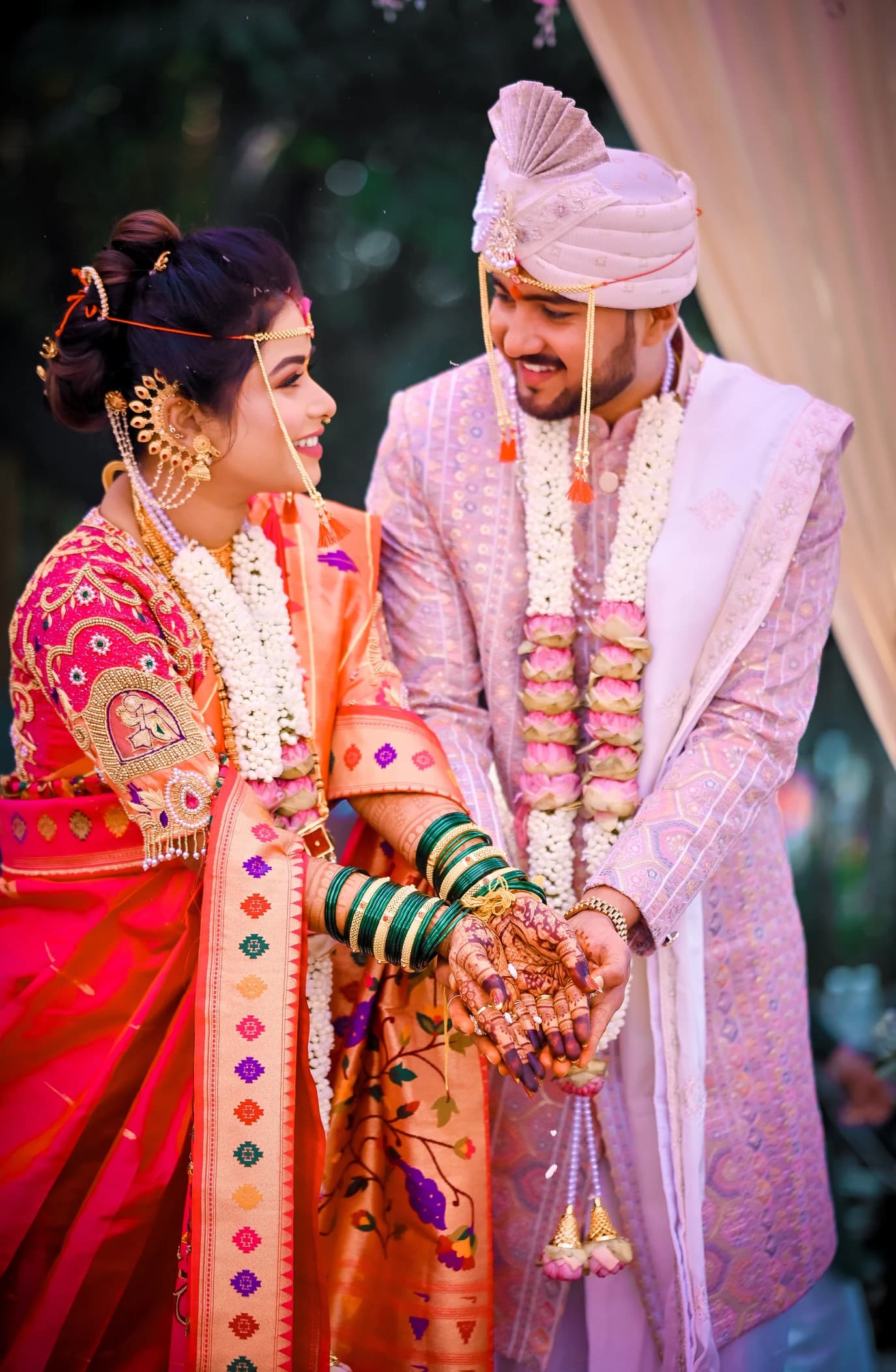 Maharashtrian bride and groom in mundavalya and flower garlands sharing a laugh